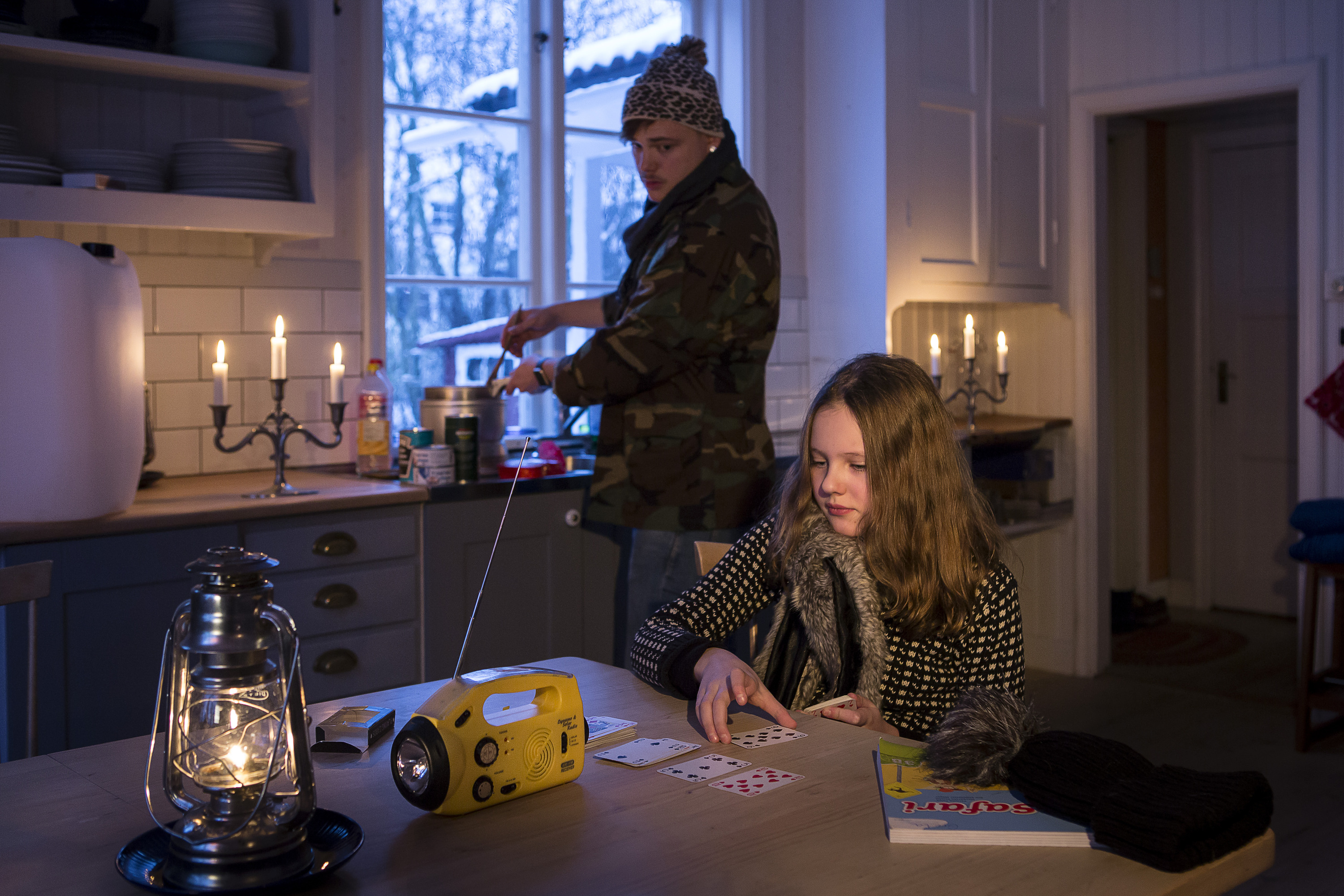 En kvinna som sitter vid ett bord i ett kök.
