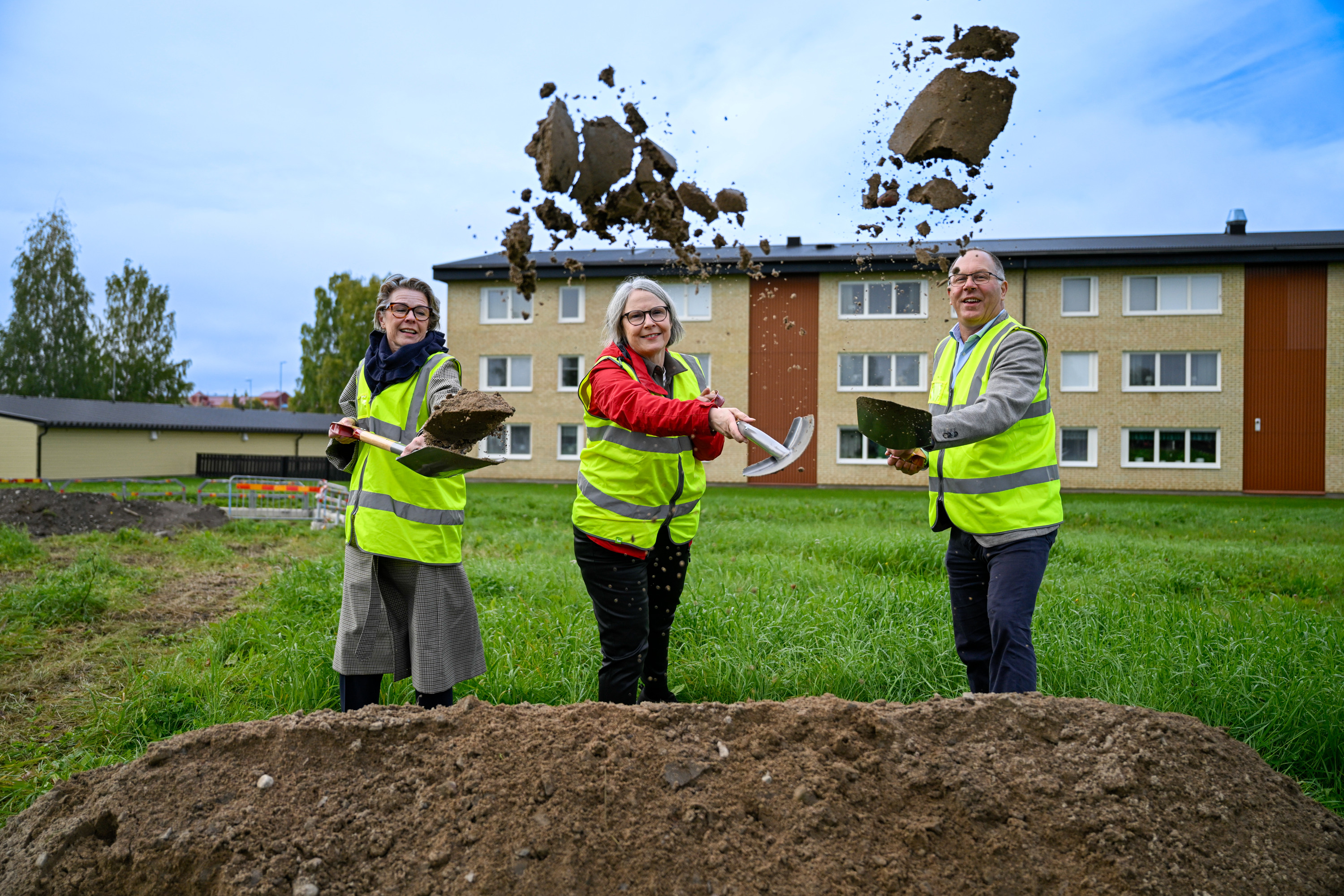 En grupp människor som står mitt på en frodig grön äng.