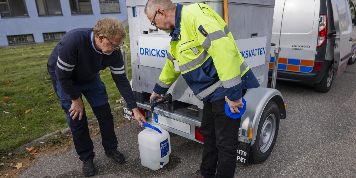 Några män som står bredvid varandra nära en lastbil.