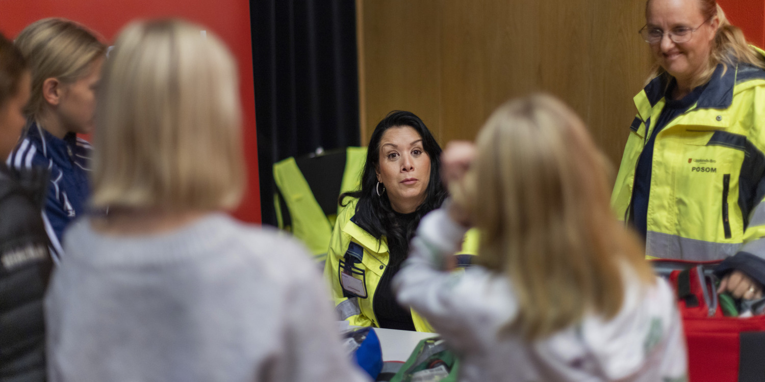 Personal från räddningstjänsten samtalar med deltagare under en träff.
